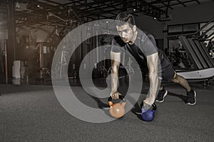 Handsome man working out  push-up strength with Kettlebell  at gym