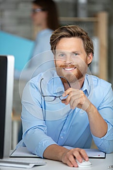 handsome manager sitting at office desk in front laptop