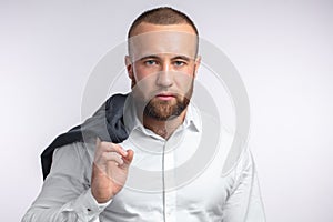 Handsome manful businessman holding his jacket over shoulder on white background photo