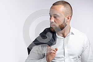 Handsome manful businessman holding his jacket over shoulder on white background photo