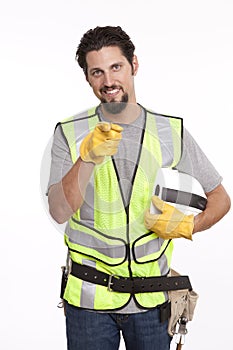 Handsome manual worker pointing towards camera