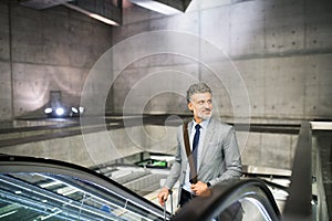 Businessman on an escalator on a metro station.