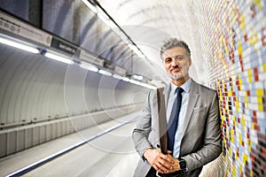 Mature businessman waiting on a metro station.