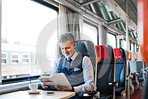 Mature businessman travelling by train.