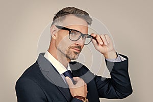 handsome mature entrepreneur in businesslike suit on grey background photo