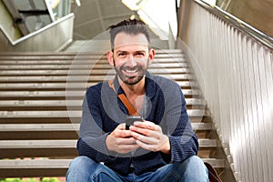 Handsome mature guy with cellphone on steps