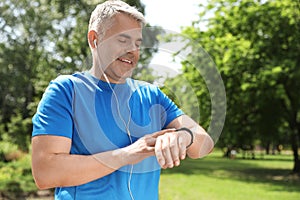 Handsome mature man looking at fitness tracker. Healthy lifestyle