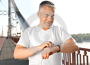 Handsome mature man looking at fitness tracker. Healthy lifestyle