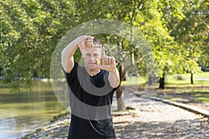 A handsome mature man looks through a frame made up of hands