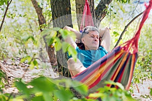 Handsome mature man resting in a hammock