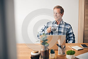 Handsome mature man sitting in front of computer