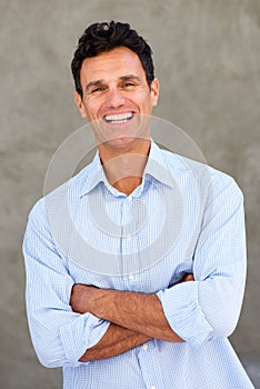 Handsome mature man smiling with arms crossed