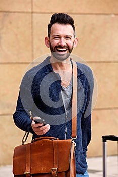 Handsome mature man standing outdoors and laughing