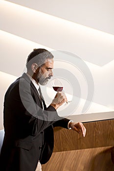 Handsome mature man tasting red wine