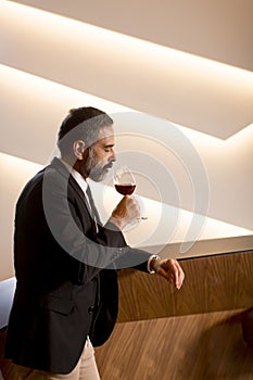 Handsome mature man tasting red wine