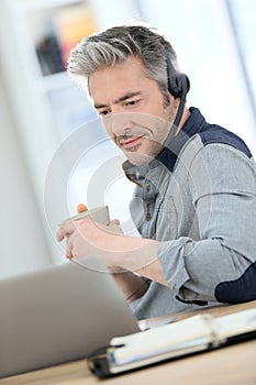 Handsome mature man teleworking from home photo