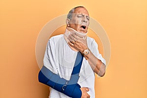 Handsome mature senior man wearing cervical collar and arm on sling touching painful neck, sore throat for flu, clod and infection