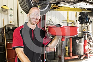 Handsome mechanic based on car in auto repair shop