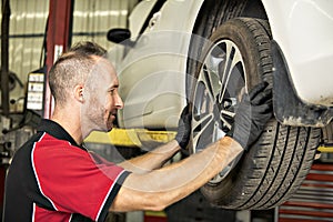 Handsome mechanic based on car in auto repair shop