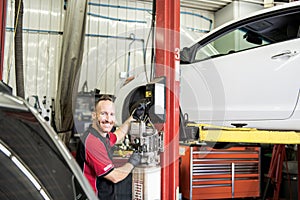 Handsome mechanic based on car in auto repair shop