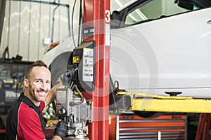 Handsome mechanic based on car in auto repair shop