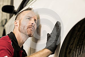 Handsome mechanic based on car in auto repair shop