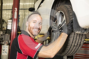 Handsome mechanic based on car in auto repair shop