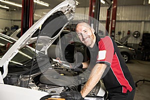 Handsome mechanic based on car in auto repair shop