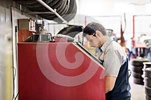 Handsome mechanic job in uniform working on car part