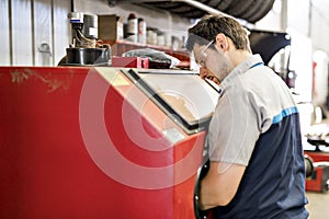 Handsome mechanic job in uniform working on car part