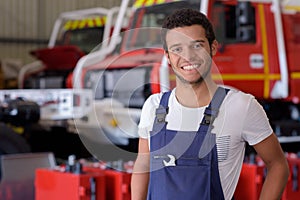 handsome mechanic near modern truck outdoors