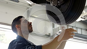 Handsome mechanic overhauling a car