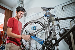 handsome mechanic working tighten the bicycle axle with a wrench