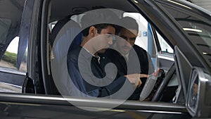 Handsome mechanics overhauling a car