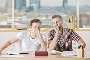 Handsome men reading book and doing paperwork