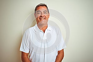 Handsome middle age man wearing polo standing over isolated white background with a happy and cool smile on face