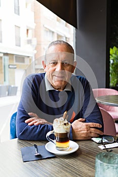 Handsome middle age senior man drinking coffee at restaurante, smiling happy enjoying and relaxing retirement
