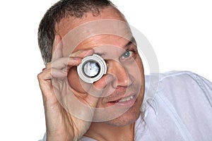 Handsome middle aged man holding lens to eye