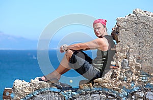 Handsome middle aged man sitting on a wall