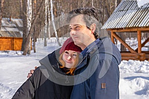 Handsome middle aged man and teen girl spending time at countryside in winter sunny day. Father and daughter walking in cottage