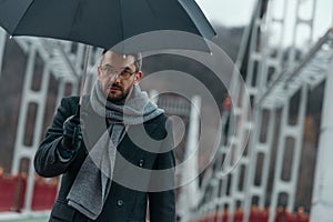 handsome middle aged man with umbrella walking photo