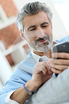 Handsome middle-aged man using smartphone