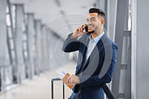 Handsome Middle Eastern Businessman Talking On Cellphone While Waiting In Airport Lounge