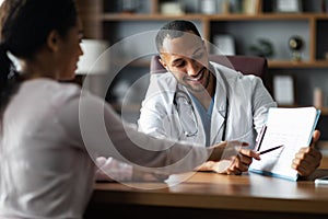 Handsome middle eastern doctor having conversation with black woman