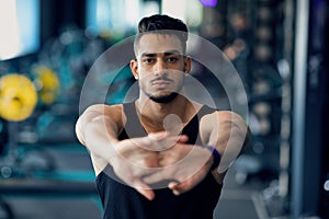 Handsome Middle Eastern Male Athlete Warming Up Before Workout In Gym