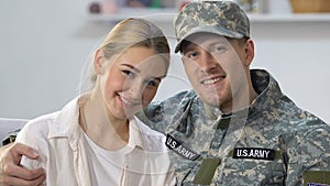 Handsome military agent hugging pretty wife, young couple love, american nation