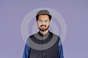 Handsome millennial man of Indian origin smiling on lilac background