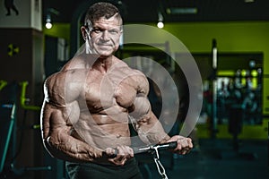 Handsome model young man training arms in gym