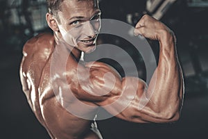 Handsome model young man training arms in gym