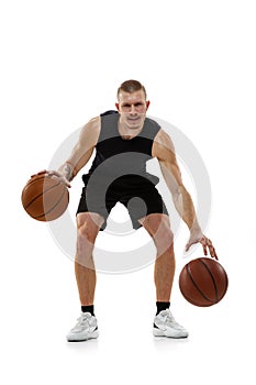 Handsome muscled man, basketball player posing with two balls isolated on white studio background. Sport, motion